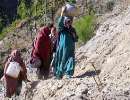 thumb for Pakistani earthquake survivors carry water pots as they walk on mud track in Balakot
