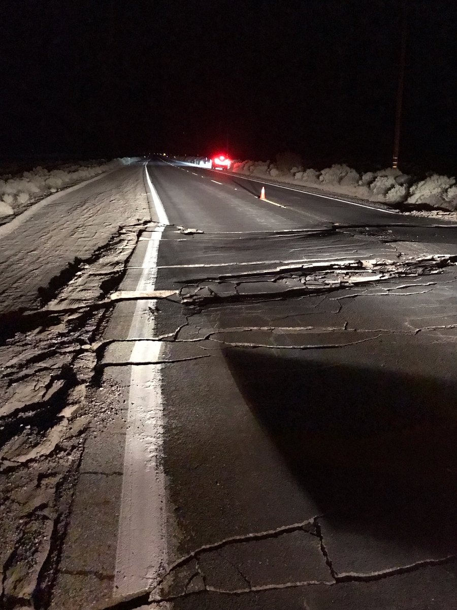 Photo showing darkened highway with a line of damaged asphalt.